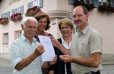 Verfasser Willy Kometer, Christine Gritsch und Maria Rosen von der Gemeindebücherei, und Vorsitzender Stephan Bammer präsentieren das Dialekt-Wörterbuch für den Isarwinkel im 20. Jahrhundert.